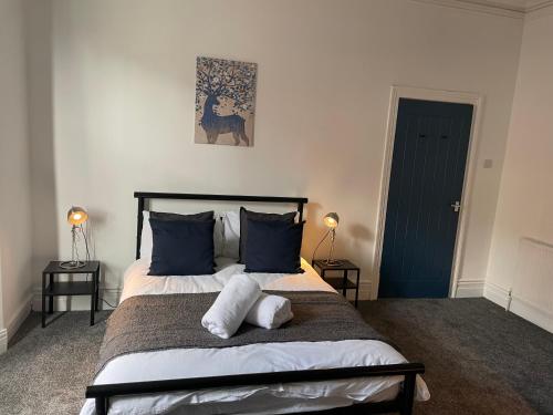 a bedroom with a large bed with blue pillows at Balfour B - Fully refurbished 2 bedrooms Ideal for Contractors and Families Free wifi Free Parking Ground Floor in Gateshead