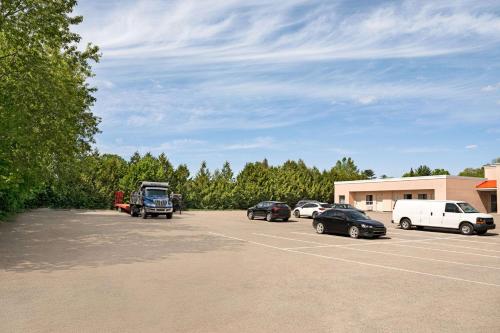 a parking lot with cars parked in front of a building at Howard Johnson by Wyndham Gravenhurst in Gravenhurst