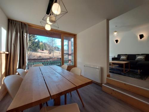 une salle à manger avec une table en bois et une grande fenêtre dans l'établissement Appartement rénové 7 personnes · Ski aux pieds · Balcon sud · Wifi gratuit - FR-1-346-313, à Arc 1800