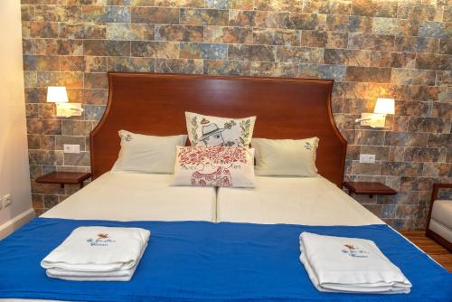 a bedroom with a bed with towels on it at Quinta da Paz in Caniço