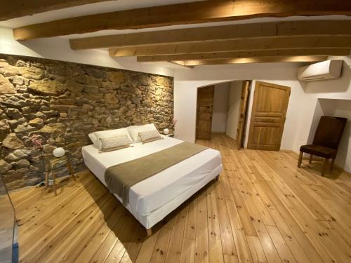 sypialnia z łóżkiem i kamienną ścianą w obiekcie Cannes Centre ville appartement atypique en duplex 85m2 w Cannes