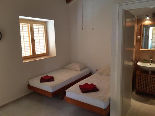 two beds in a room with a sink and a mirror at Villa Splendissima Krk - Adults only in Krk