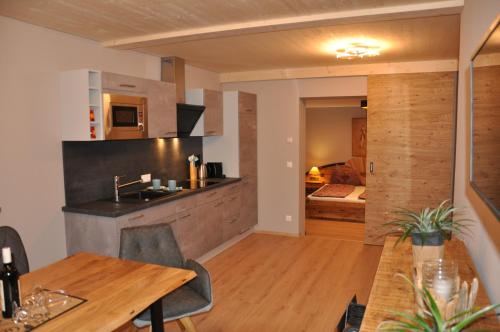 a kitchen and dining room with a wooden table at Himmelsbögen und Apartments mit Seeblick und Alleinlage in Weissensee