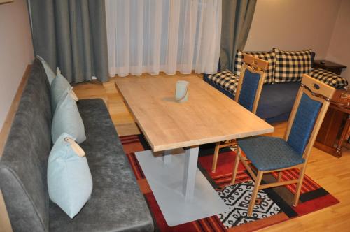 a living room with a couch and a table at Himmelsbögen und Apartments mit Seeblick und Alleinlage in Weissensee