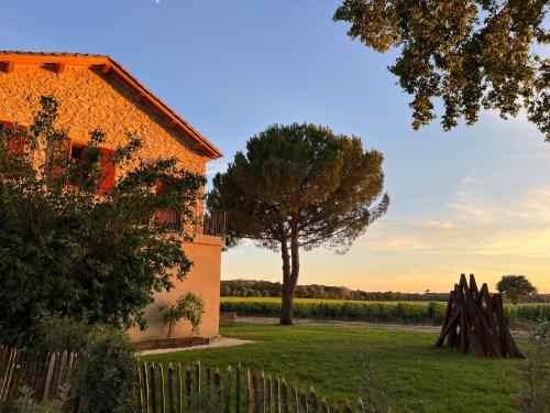 a farm house and a tree and a fence at Domaine de Panery in Pouzilhac