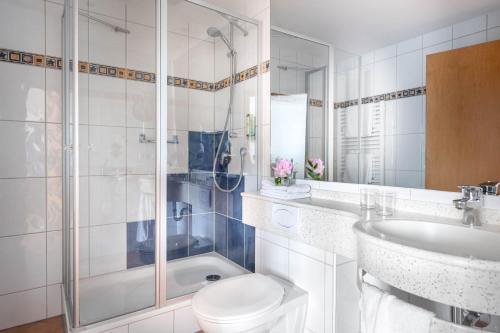 a bathroom with a toilet and a sink and a shower at Ringhotel Krone in Friedrichshafen