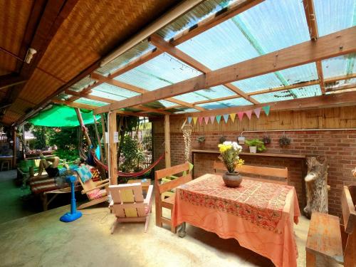 d'une terrasse avec une table et des chaises ainsi qu'un toit en verre. dans l'établissement Sunny garden hostel, à Pai