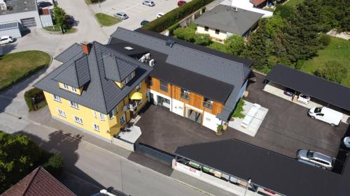 an overhead view of a yellow house with a black roof at Kummers Motel in Völkermarkt