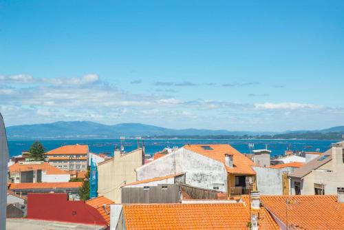 a view of a city with orange roofs at Apartamento Mar do Grove in O Grove