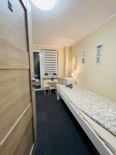 a room with a bed and a table and a door at Apart Rooms City Centre in Warsaw