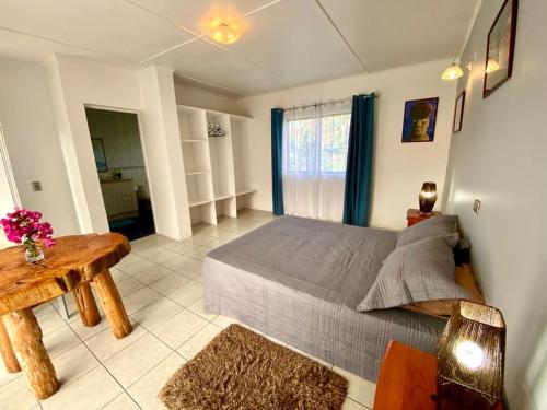 a bedroom with a bed and a table and a window at Kahina Lodge in Hanga Roa