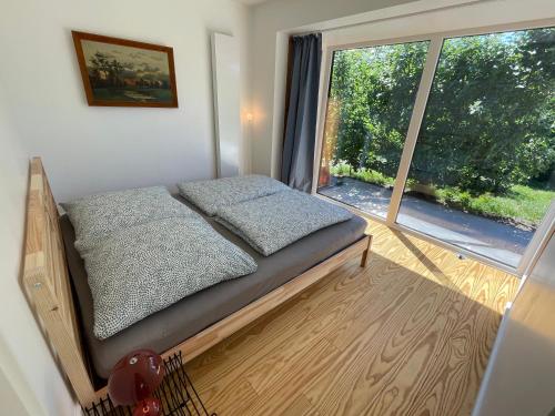 um pequeno quarto com uma cama e uma grande janela em Ferienhaus Aalglatt am Deich, 250 m zum Strand em Dierhagen