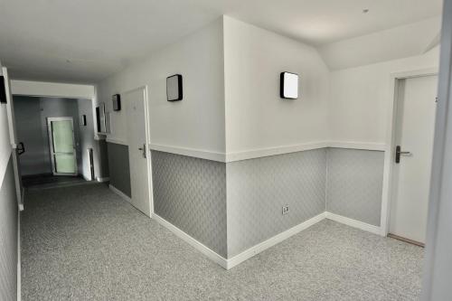 a hallway with white walls and a hallway with a door at Pokoje Gościnne u Klimosza in Pogwizdów