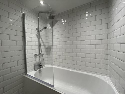 a bath tub with a glass shower in a bathroom at Fellseeker in Keswick