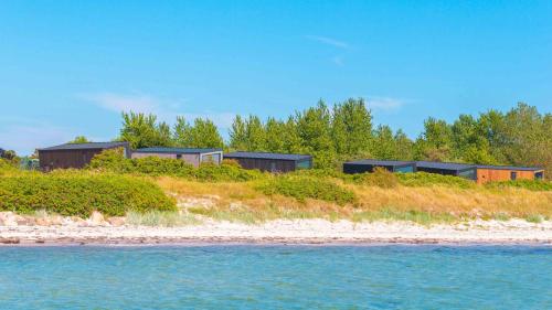 un grupo de casas en una colina junto al agua en Tiny Seaside - Kegnæs, en Østerby
