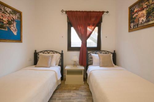 two twin beds in a room with a window at Apartments Bonaca in Kotor