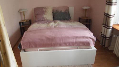 een bed met een roze deksel erop bij Zentral gelegene Ferienwohnung in Lübeck