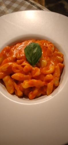 a bowl of pasta with a green leaf on top at B&B Tenuta San Michele in Capaccio-Paestum
