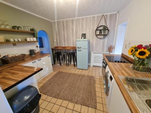 a kitchen with a refrigerator and a table at The Annexe at Tenniside • Private Garden • Hot Tub in Perranporth