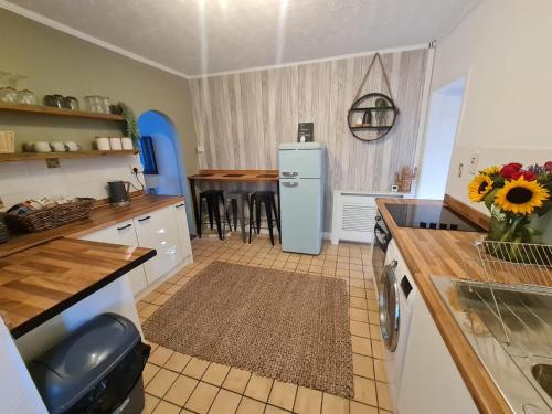a kitchen with a refrigerator and a table at The Annexe at Tenniside in Perranporth