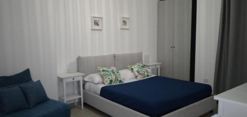 a bedroom with a blue bed and a couch at B&B Tenuta San Michele in Capaccio-Paestum