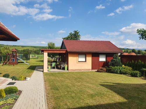 a small house with a garden and a playground at Šarmír Apartmány in Bobrovec