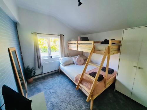 a bedroom with two bunk beds and a window at The Annexe at Tenniside • Private Garden • Hot Tub in Perranporth