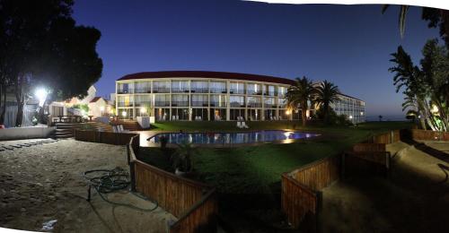 a building with a pool in front of it at night at Wilderness Beach Hotel in Wilderness