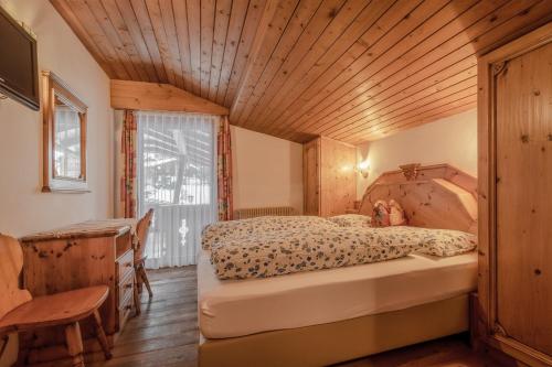 a bedroom with a bed and a wooden ceiling at Garni Cristallo in San Vigilio Di Marebbe