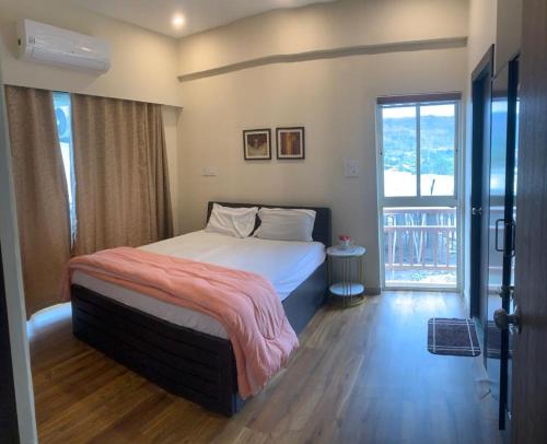 een slaapkamer met een bed en een groot raam bij THE DECK in Karjat
