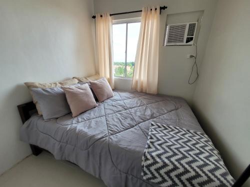ein Schlafzimmer mit einem Bett und einem Fenster in der Unterkunft Phamz Unit in Bacolod City