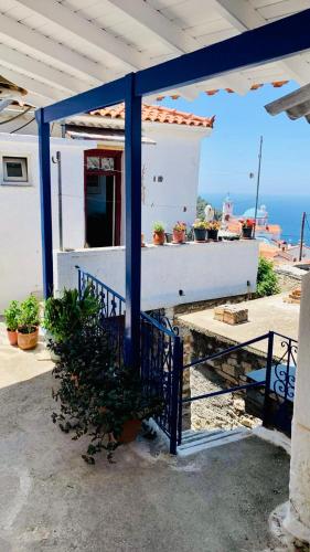 a house with a blue railing and a table with plants at Άκρη του κόσμου in Samos