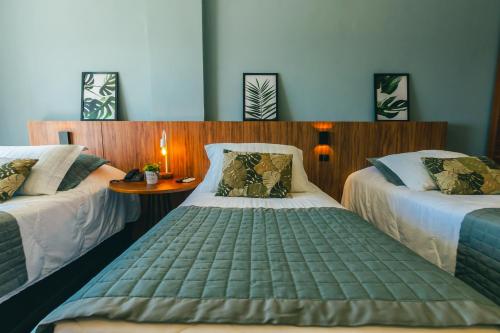 Habitación con 2 camas y una mesa pequeña con 1 cama doble en Hotel Villareal São Francisco do Sul en São Francisco do Sul