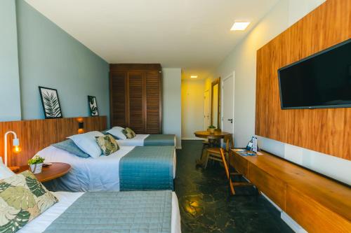 Habitación de hotel con 2 camas y TV de pantalla plana. en Hotel Villareal São Francisco do Sul en São Francisco do Sul