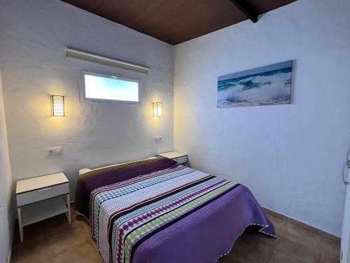 mała sypialnia z łóżkiem i oknem w obiekcie Casita cerca de la playa para 2 personas w Kadyksie