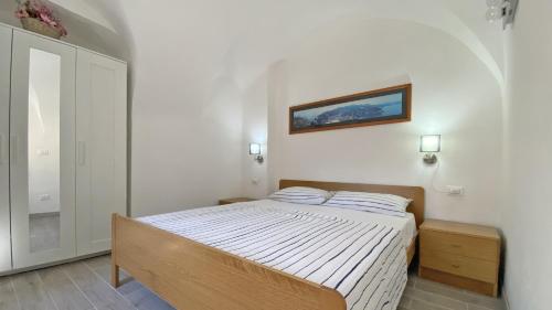 een slaapkamer met een bed en een foto aan de muur bij LA CASA DEL BORGO nature sport & relax 1room apartment with garden and private park in Calice Ligure
