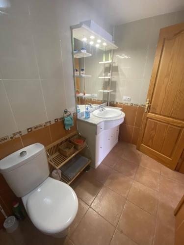 a bathroom with a white toilet and a sink at ALE´S HOUSE in Arrecife