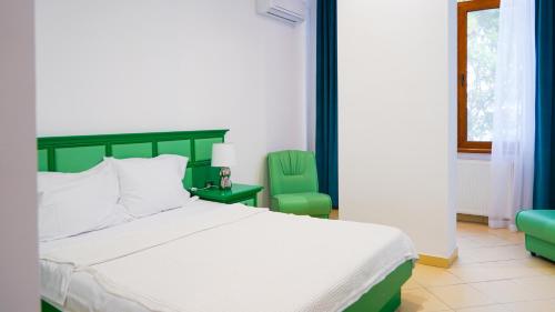 1 dormitorio con 1 cama y 2 sillas verdes en Complex Vile Neptun-Olimp, en Olimp