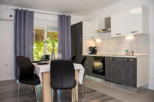 eine Küche mit einem Tisch und schwarzen Stühlen in einem Zimmer in der Unterkunft Apartment 7 in Novi Vinodolski