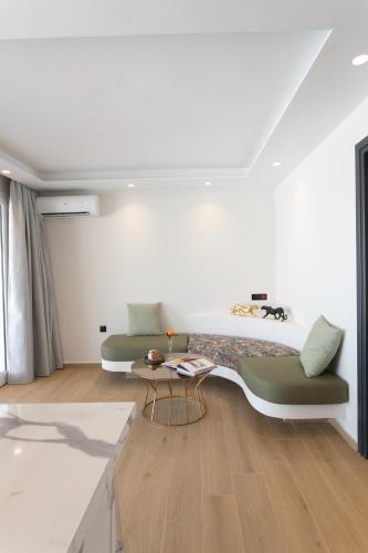a white room with a bed and a table at Iphimedeia Luxury Hotel & Suites in Naxos Chora