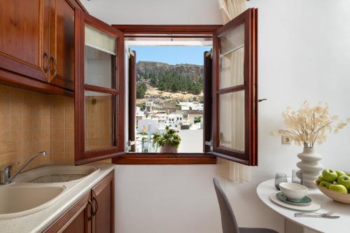 a kitchen with a sink and a window at Lindos Luxury Belfry Apartment in Líndos