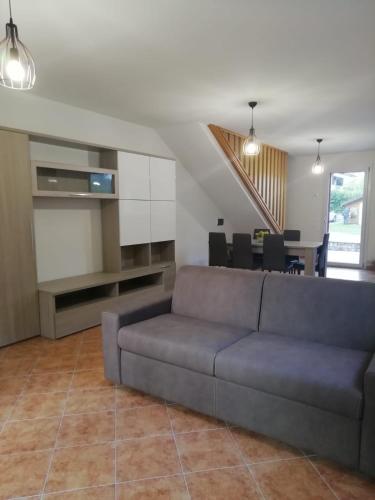 a living room with a couch and a dining room at Residence TANA - via Pasubio in Enego