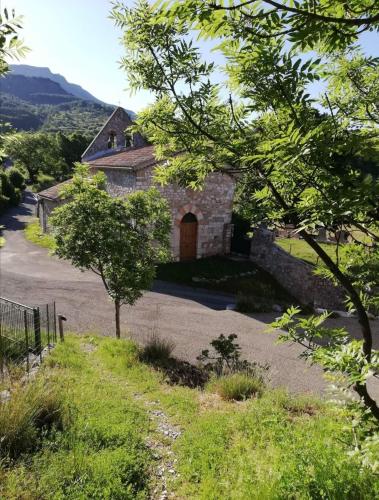 an old stone building with a door in a yard at Gite L'EISSAME in Valavoire