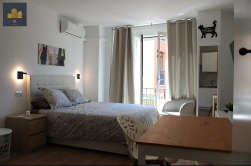 マラガにあるLuxury Estudio Malaga Centroのベッドルーム1室(ベッド1台、テーブル、窓付)