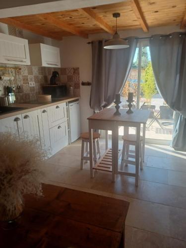 une cuisine avec une table et des chaises et une fenêtre dans l'établissement La Vigne, à Sorgues