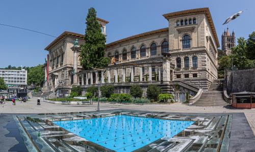 un bâtiment avec une piscine en face d'un bâtiment dans l'établissement Studio SIEVA, à Lausanne