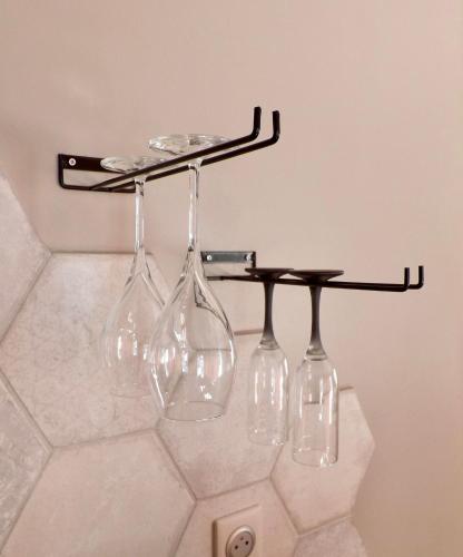 un casier à vin avec quatre verres à vin dessus dans l'établissement La Suite Côté Pool-House Piscine, Sauna & Jacuzzi privatifs, à Istres