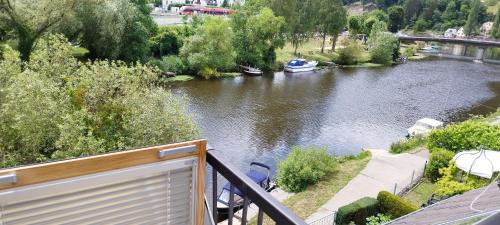 a balcony with a view of a river with a boat at Ferienwohnung Toni in Obernhof