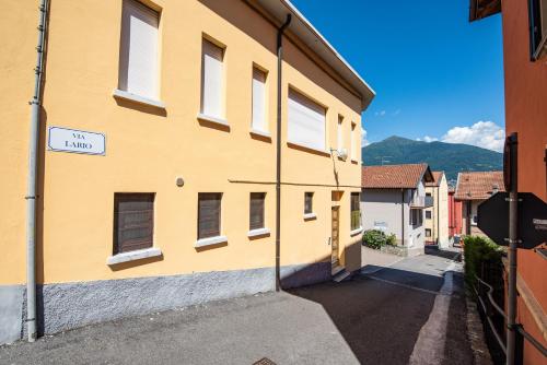 a yellow building with a street sign on the side at CasaCamelia 35, 3 BDRM with view Lake Como in Acquaseria
