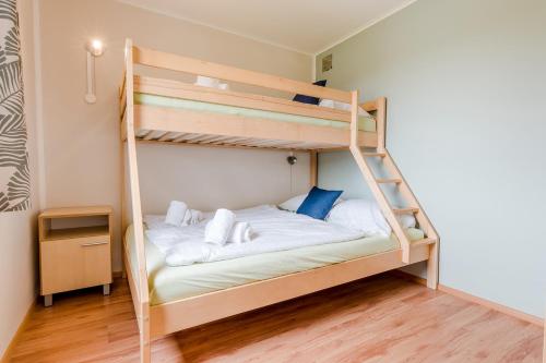 a bedroom with a bunk bed with a ladder at Relax Camping Seewirt in Feldkirchen in Kärnten